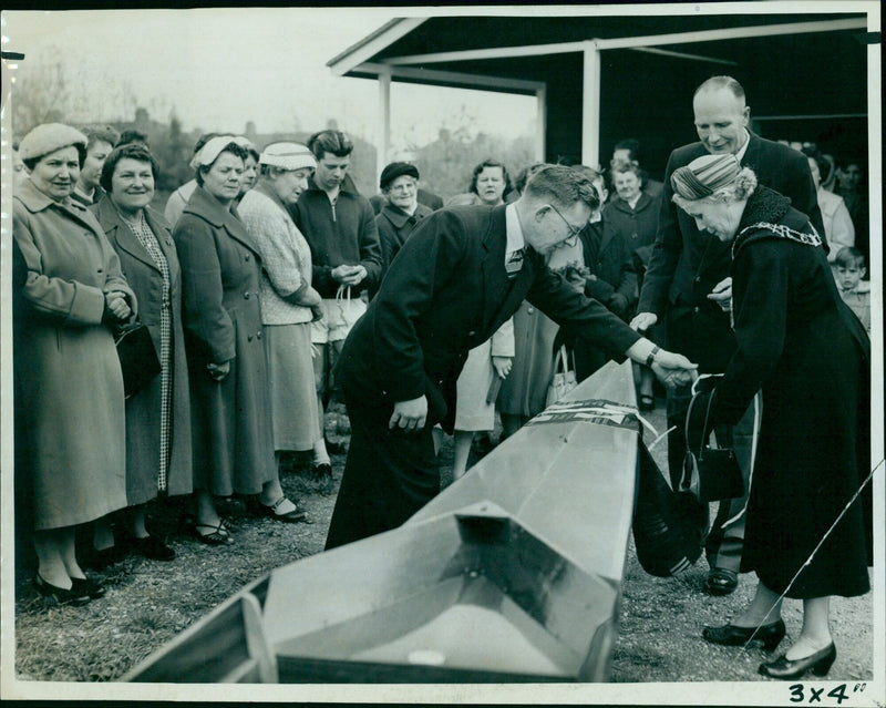 Ald. Lady Townsend christens a new rowing shell with a bottle of champagne. - Vintage Photograph