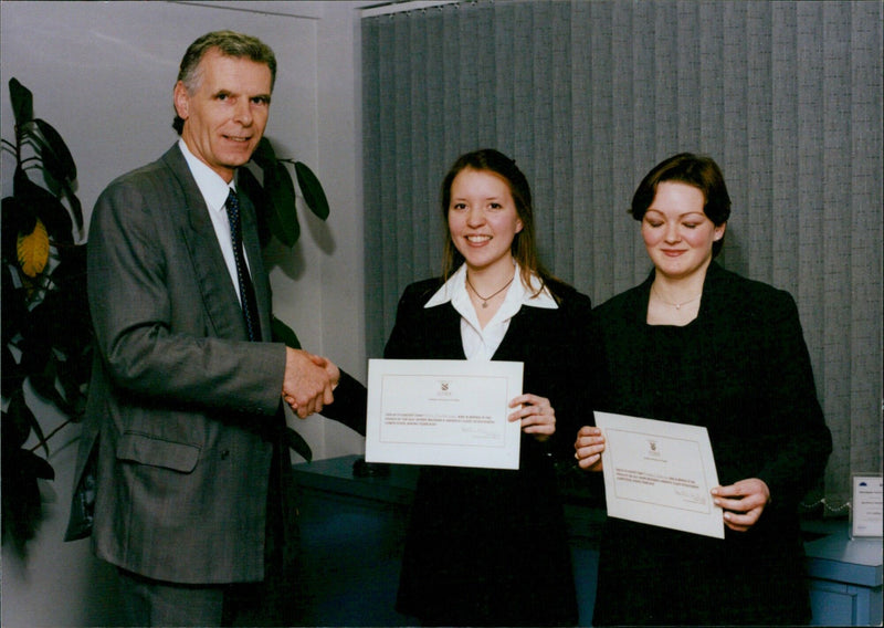 Martin Allen, Partner of Donne Mileham & Haddock, and Amy Richardson, Nikada Griffith, pose for a photograph during a meeting in Oxford. - Vintage Photograph