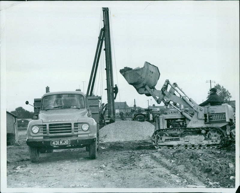 Construction workers operating heavy machinery on a building site in Cowley, Oxfordshire. - Vintage Photograph