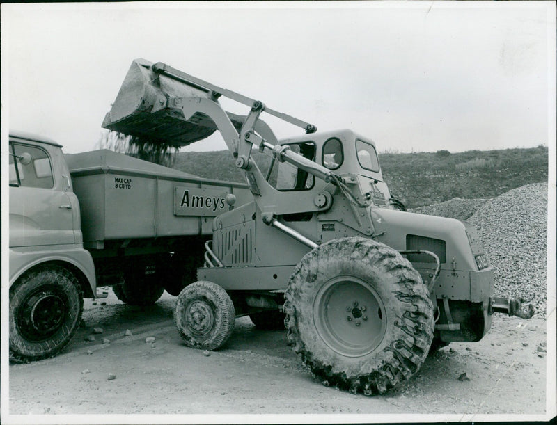A Weatherill-Hydraulic 12.H loading shovel discharging crushed stone into a truck at a stone quarry. - Vintage Photograph