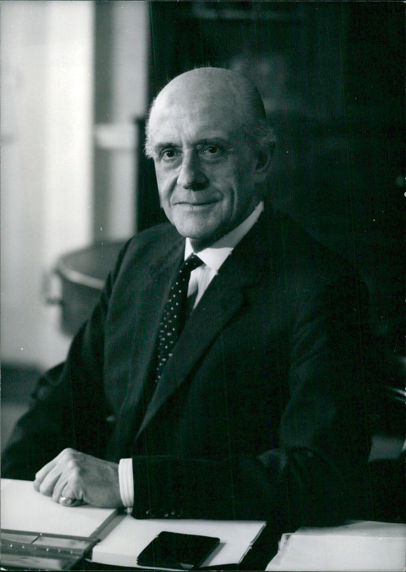 British personalities John Hastings James, Deputy Master and Comptroller of the Royal Mint, and ex officio Engraver of H.M.'s seals, smiles for a portrait study by Baron Studios Camera Press London International, taken in 1979. - Vintage Photograph