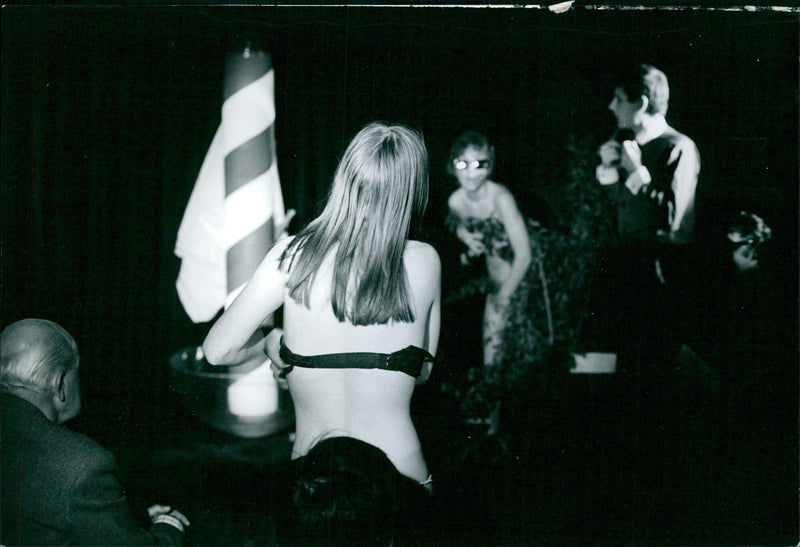 A group of men and women enjoy the summer sun in the nude at a beach in Hulm, Sweden, on August 2, 1968. - Vintage Photograph