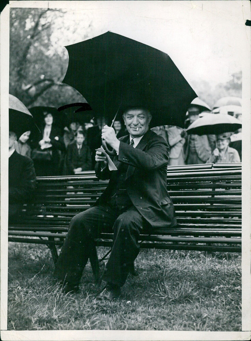 Swedish Prime Minister Per Sandels smiles despite the pouring rain while attending the 8711 jubilee congress at Skansen in Stockholm on July 24, 1938. - Vintage Photograph