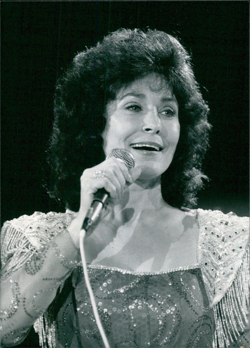 Loretta Lyn, the first woman ever selected as Entertainer of the Year by the Country Music Association, performs onstage with her good friend Conway Twitty. - Vintage Photograph