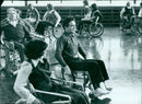 Wheelchairs line the hallways of a hospital in 1977. - Vintage Photograph