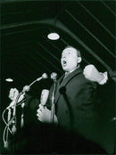 A man stands amongst a crowd of protesters in Paris, France, holding a sign that reads "Tohal 8727 Michel Debre", as they demonstrate against the government. - Vintage Photograph