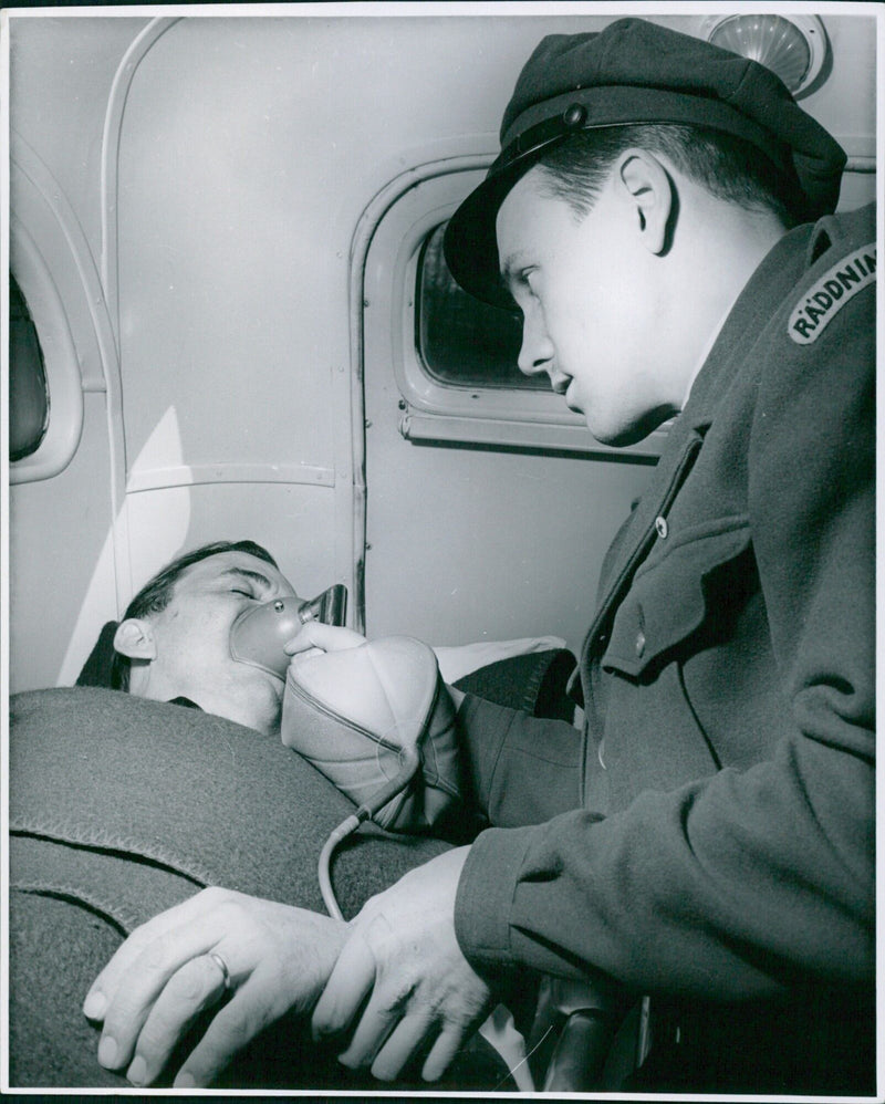 Emergency medical personnel prepare to transport patients in an ambulance. - Vintage Photograph