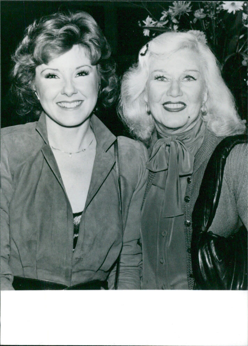 U.S. actresses Ginger Rogers and Lisa Donovan meet at a reception to celebrate the reissue of the first volume of the Academy Players Directory, a casting directory that first published in 1937. - Vintage Photograph