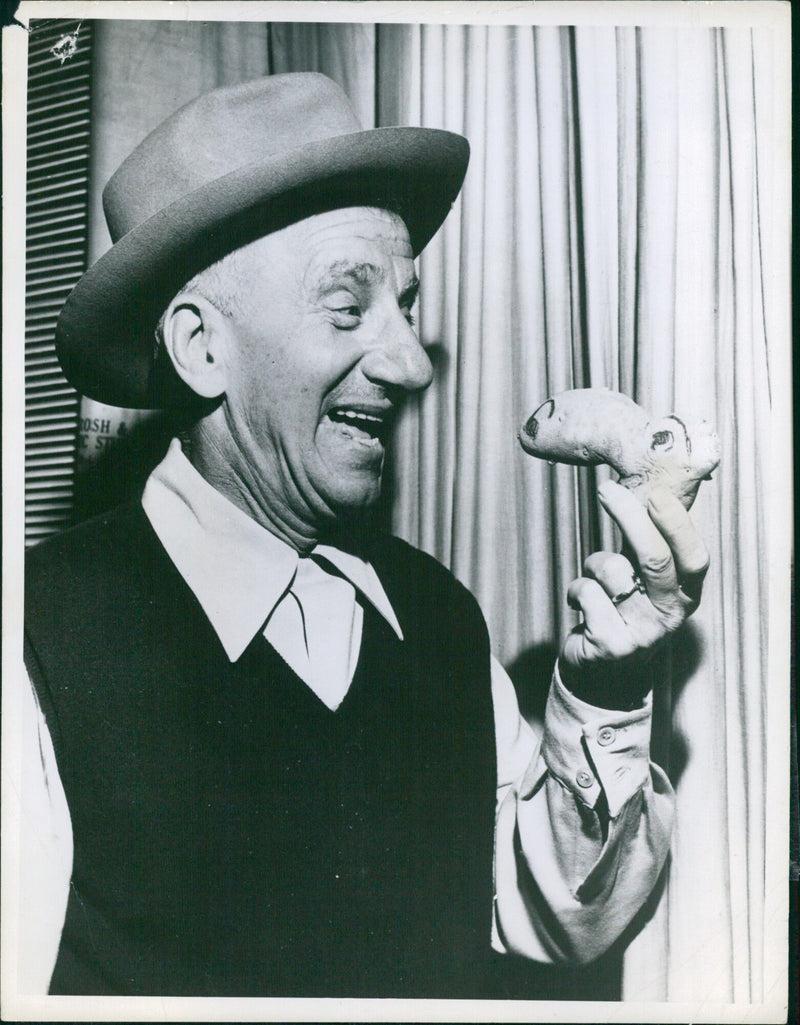 Idaho potato growers present comedian Jimmy Durante with a spud counterpart in recognition of his selection as "Mr. Some Potatoes". - Vintage Photograph