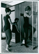Teenage girls use machines and exercises to spot reduce too-plump areas at a glamour farm. - Vintage Photograph