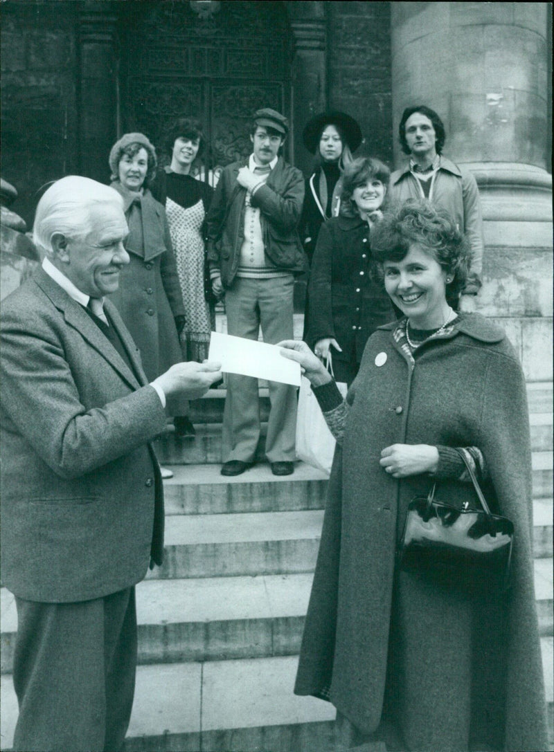 On October 30, 1979, Susan Marshall (right) of Animal Aid presented a letter to Wilfred Heath of The Clarendon, Oxford University, calling for an end to "unspeakably cruel experiments" conducted in the university's laboratories. - Vintage Photograph