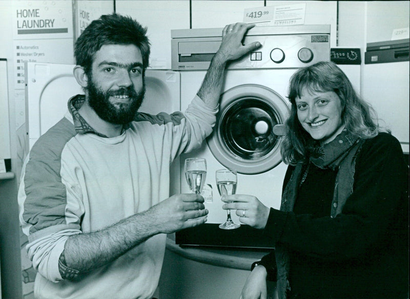 Nick and Sarah Hindmarsh toast their newly purchased washing machine after queuing for 28 hours at Rumbelows. - Vintage Photograph