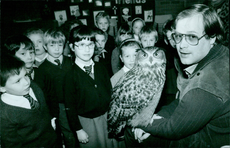 Daniel Stares poses for a photograph with "ERIC" the Eagle Owl at St. Josephs School in Oxford. - Vintage Photograph