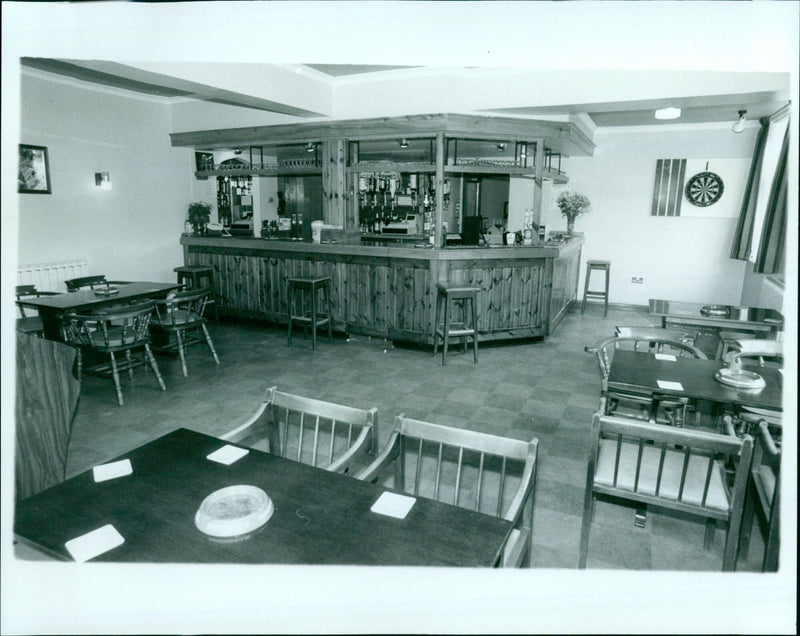 A group of friends enjoying a meal together at a public bar. - Vintage Photograph