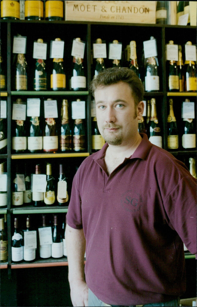 Richard Harrop, Manager of Stevens Garnier Ltd wine merchants, with a bottle of Moet & Chandon. - Vintage Photograph