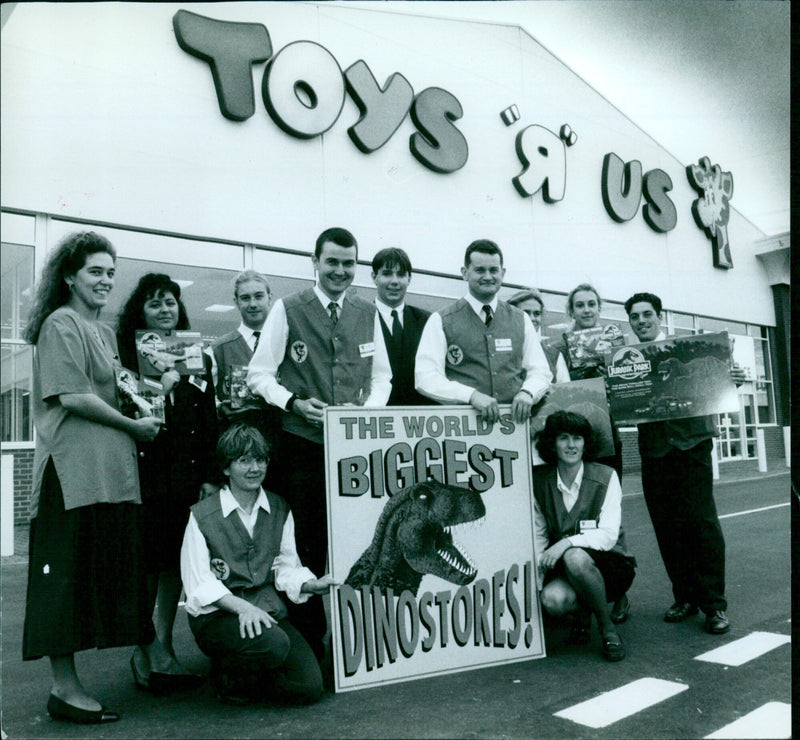 Toys 'R' Us employees pose at Jurassic Park Atsar ox shops in 1990. - Vintage Photograph