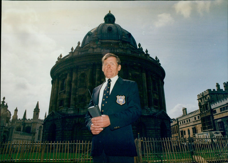 A custodian stands in front of Oxford's Zadclifte Square on May 17, 1991. - Vintage Photograph