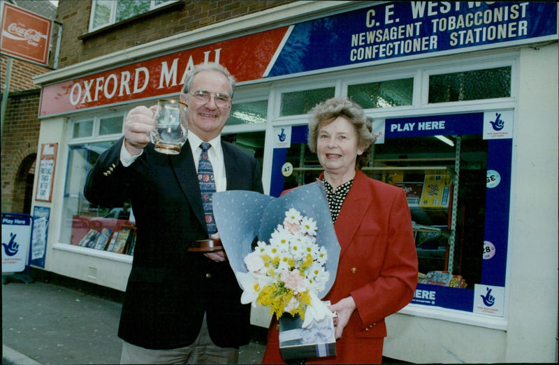 Eric and Pat Westwood, retiring newsagents, are presented with flowers, chocolates, and a tankard in recognition of their hard work for the Oxford Mail. - Vintage Photograph