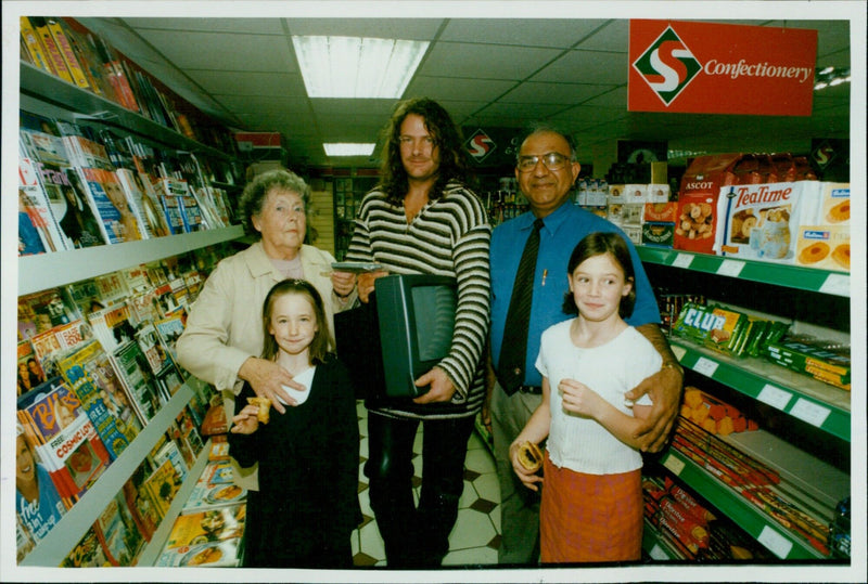 Peter Bisson receives a telephone from Mrs. Valerie Lewis and Mo Afzal of Select and Save during a presentation at Abingdon Road, Oxford. - Vintage Photograph