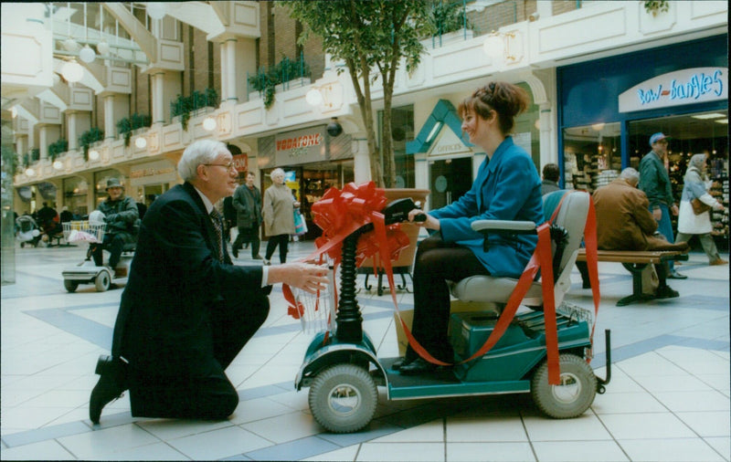 Ken Brown presents Vicky Hancock with a tricycle at Westgate shopping centre. - Vintage Photograph