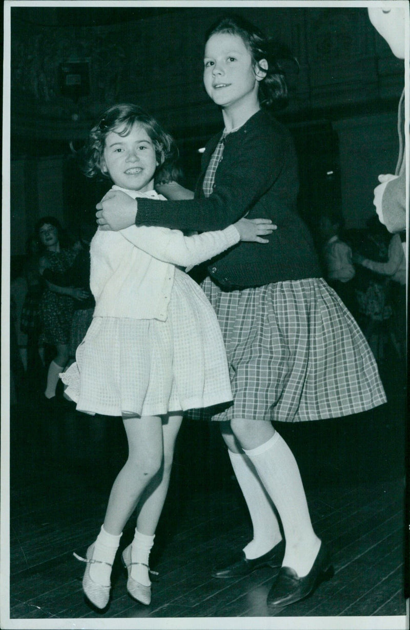 English folk dancers Leita Hodgkinson (8) and Katherine Belcher (both from Kidlington) perform a traditional dance in the Nimepins Hall. - Vintage Photograph