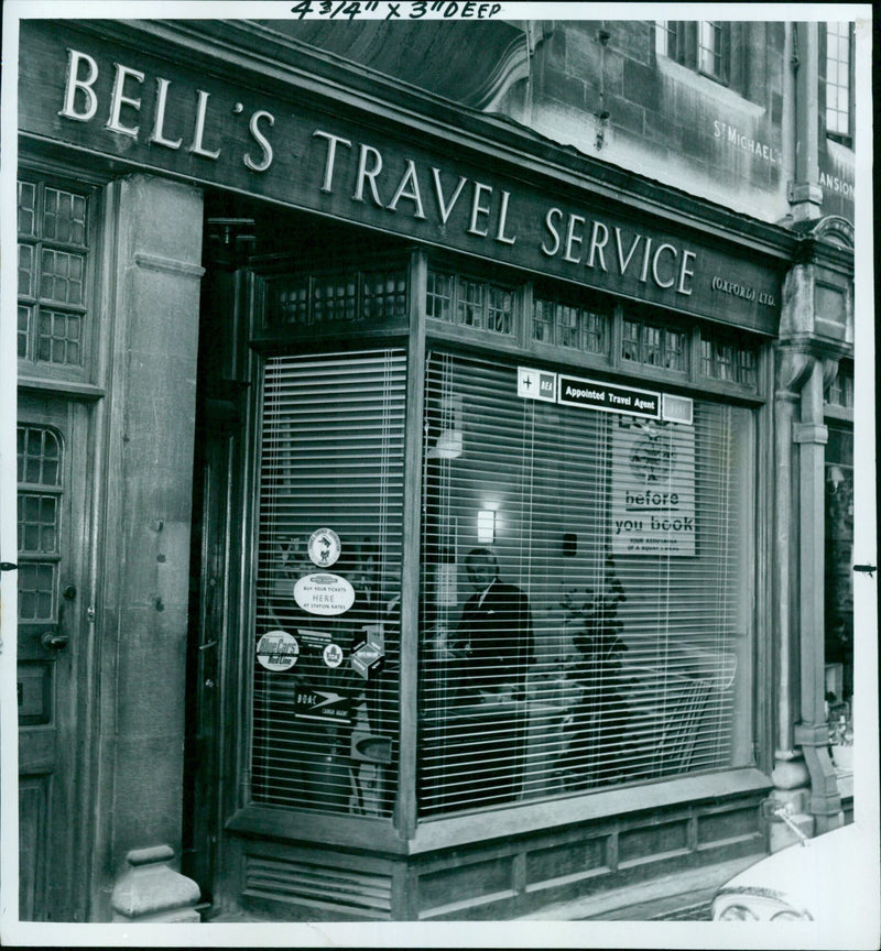 Passengers wait in line for tickets at Bell's Travel Service in Oxford, England. - Vintage Photograph