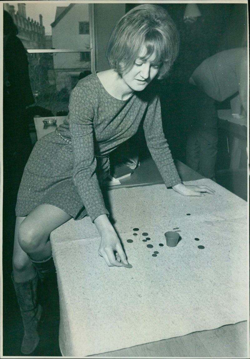 Doris Nicholson of Linacre College, Oxford, flips a wink into the cup during an inter-varsity tiddlywinks match against Cambridge University. - Vintage Photograph