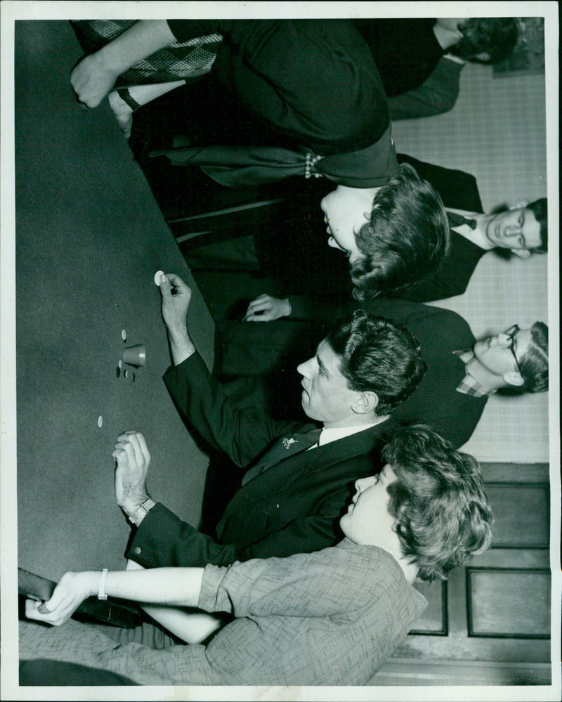Oxford University captain Nigel Maggs winking during a tiddlywinks match against London University. - Vintage Photograph