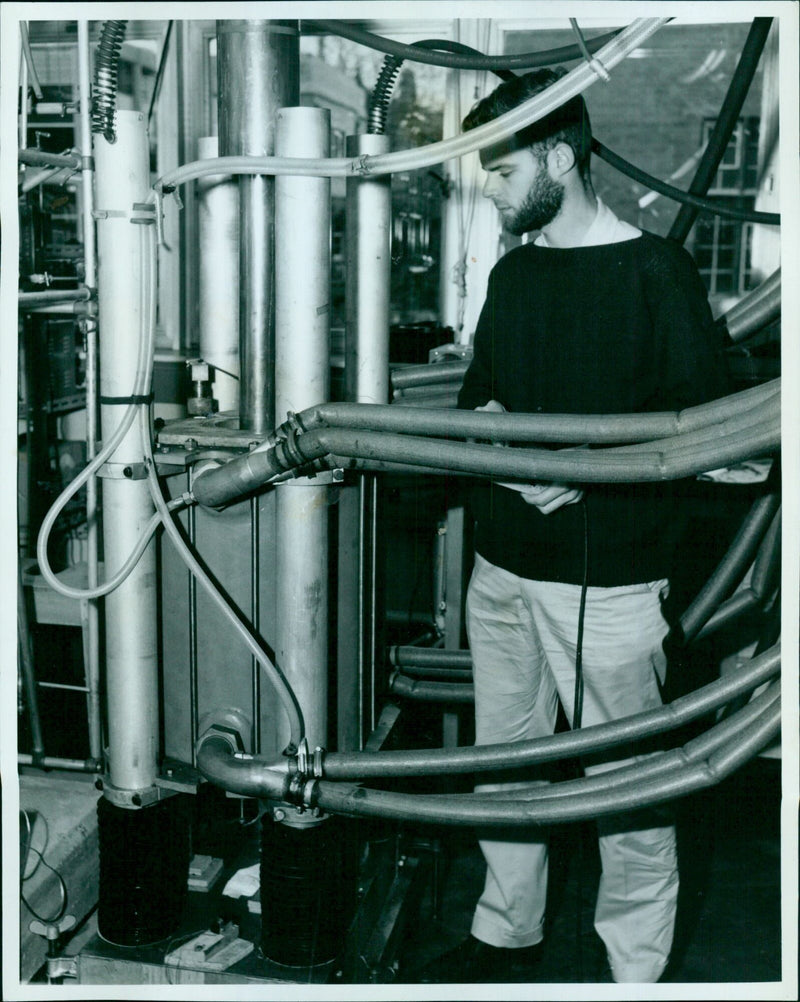 Mr. R.H. Marsh, a DPhil student from Dalhousie University, Canada, operates a large electromagnet by remote control in the Ox Clarendon Nullard Cixando Laboratory. - Vintage Photograph