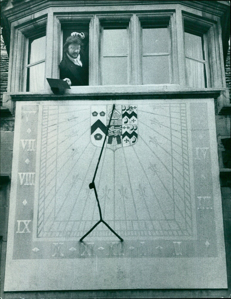 A student at Brasenose College in Oxford struggles to turn back time on a sundial. - Vintage Photograph