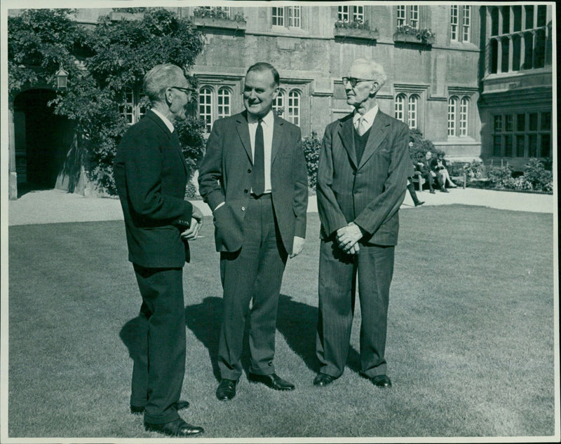 Jesus College Principal H. J. Habakkuk honors two staff members for their 120 years of combined service. - Vintage Photograph