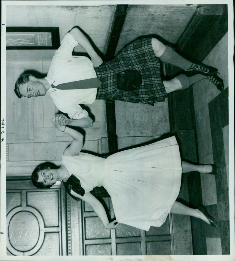 Mr. Philip Powell and Miss Jennie Lay of the Oxford University Scottish Society practice their part in the Foursome Reel at an Oxford Town Hall event. - Vintage Photograph