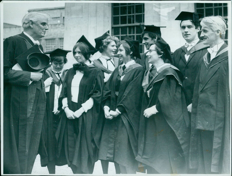 Oxford University's first B.Ed. graduates step out of the Sheldonian Theatre wearing their new beetle-green hoods. - Vintage Photograph