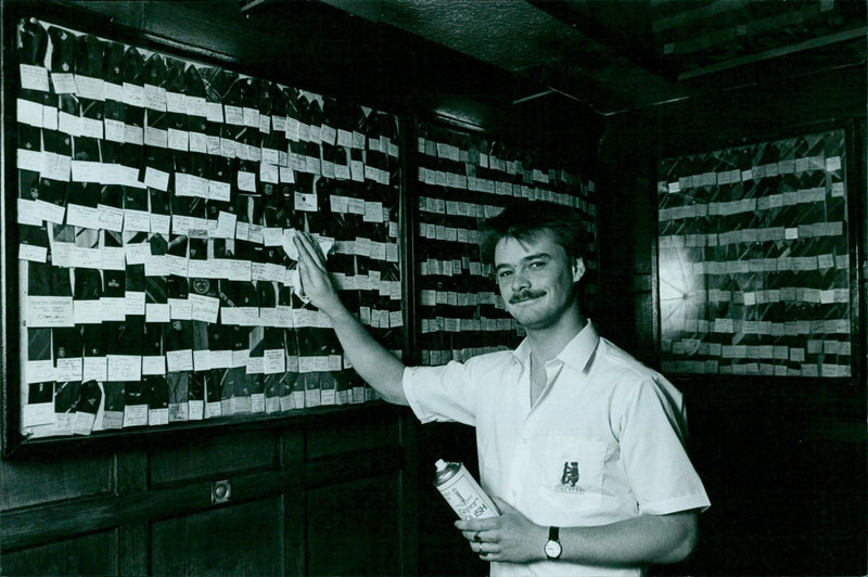 Paul Knight polishes the glass cases of the Bear pub in Oxford. - Vintage Photograph