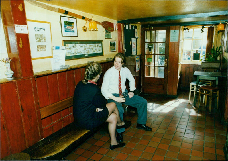 A man repairs a Mism Ganw machine at the Rose & Crown pub in Oxford, England. - Vintage Photograph