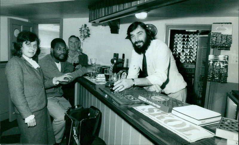 A man enjoys a beer at a bar in London, UK. - Vintage Photograph