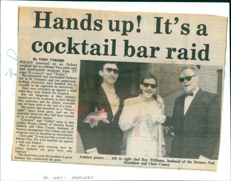 Police officers raid a cocktail bar in Oxford, England, only to find two men dressed in Miami Vice-style costumes with fake weapons. - Vintage Photograph