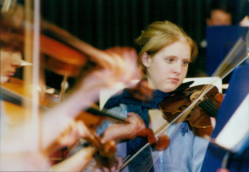 Violinist Liz Yarrow performs during a school performance of Beethoven's Fifth Symphony. - Vintage Photograph