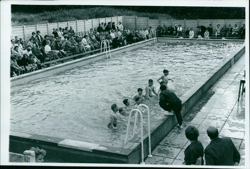 P.E. Instructor Mr. W. Thomas gives instruction to learner swimmers at the official opening of the new swimming pool at XXXH Matthew Arnold School. - Vintage Photograph