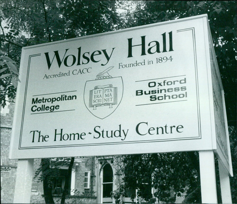 A robber wearing a crash helmet steals cash from two women at Wolsey Hall college in Oxford, UK. - Vintage Photograph