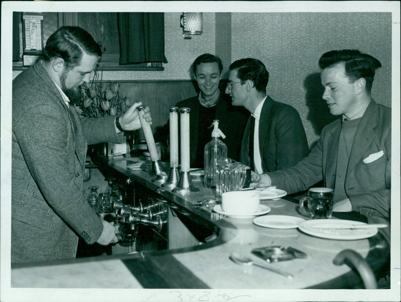 A group of friends enjoy a bowl of curry in the bar of the Abingdon Arms in Oxford, England. - Vintage Photograph