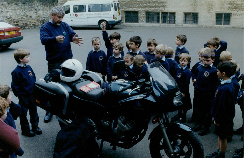 Head of Chi Chi Cathedral School in Oxford, Allan Mottram, shows off his motorbike to pupils. - Vintage Photograph