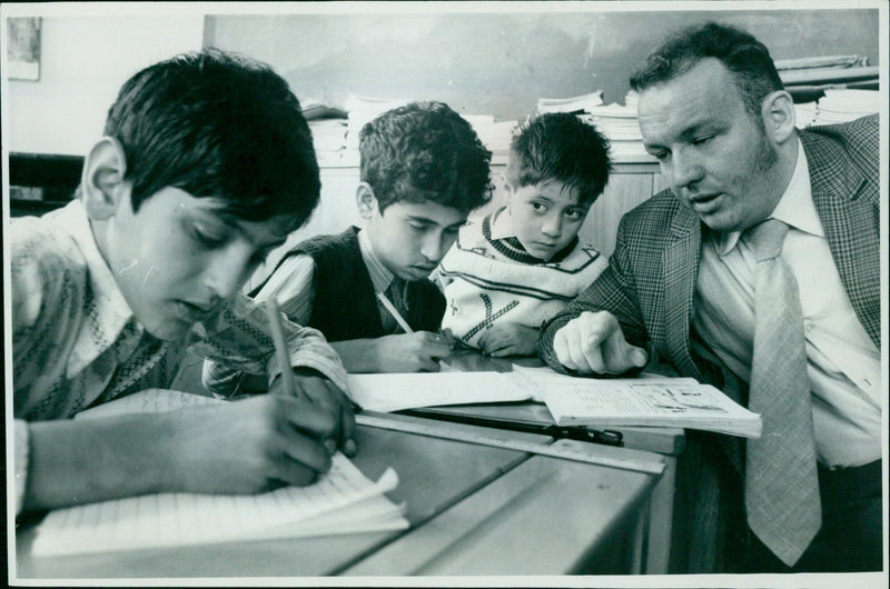 Teacher John Barwell gives dictation to students Afzal Mehdi, Saleel Knanx, and Nasir Khan at an Oxford summer school. - Vintage Photograph