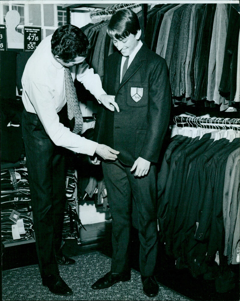 Army personnel receive uniforms during a fitting session. - Vintage Photograph