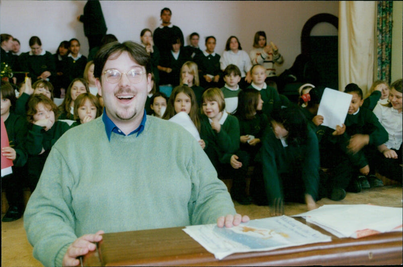 Music teacher Stephen Russen stands with the Wesley Green Middle School choir at Blackbird Leys. - Vintage Photograph
