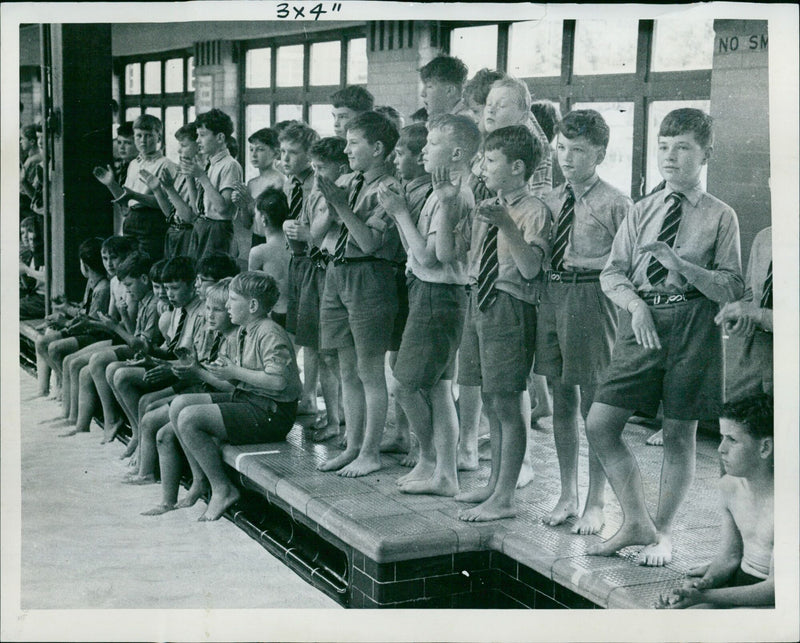 New College School boys watch their schoolmates racing in the annual swimming sports. - Vintage Photograph