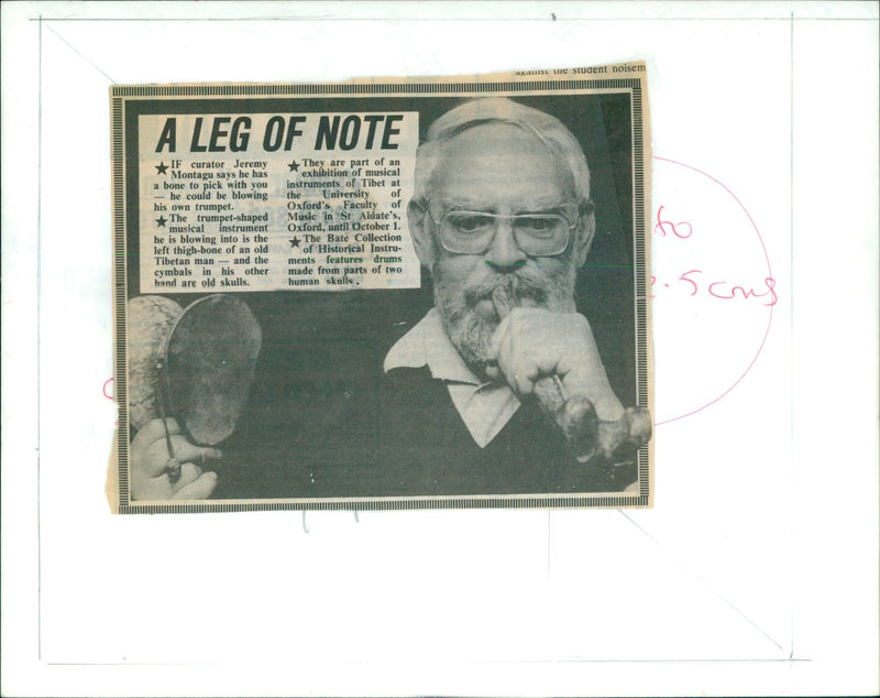 Curator Jeremy Montagu blows into a trumpet-shaped instrument made from the left thigh-bone of an old Tibetan man. - Vintage Photograph