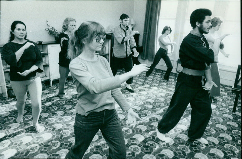 Students of a tai chi class practice their movements. - Vintage Photograph