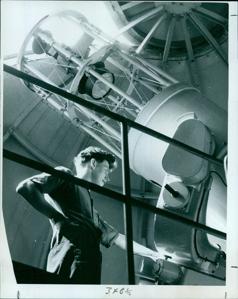 Mr. David Lambert adjusts a telescope at Oxford University Observatory. - Vintage Photograph