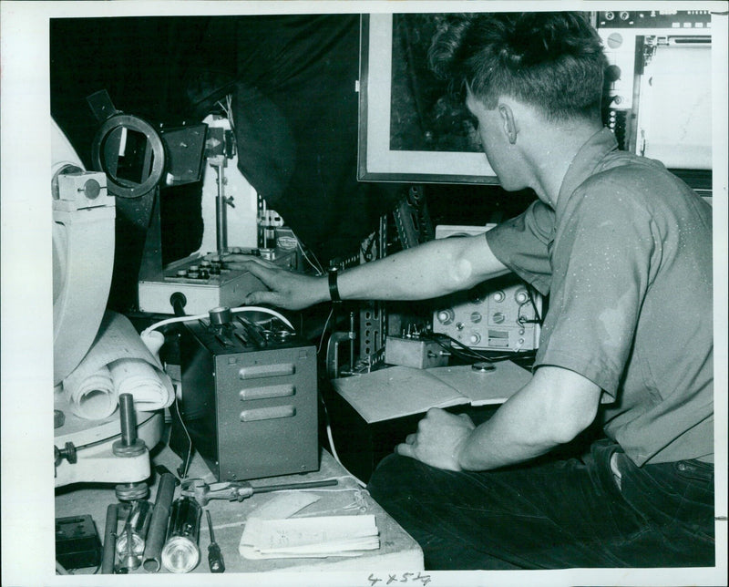 A man holds a device containing a solar-powered fan he designed in Bala, India. - Vintage Photograph